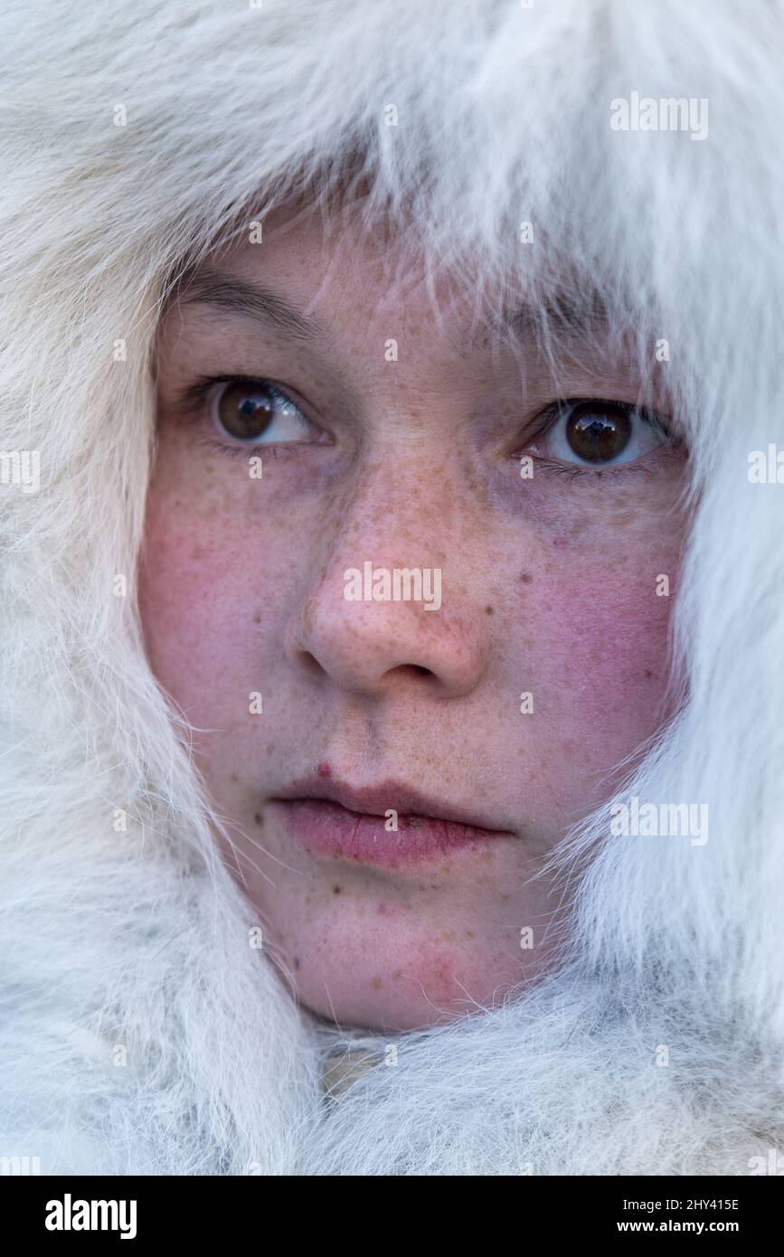 Close-up portrait of a beautiful Nenet girl with reindeer fur hood at ...