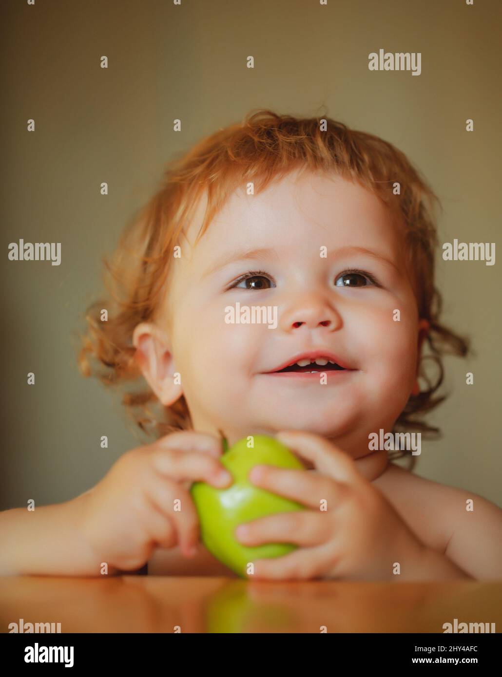 Launching child eat. Charming baby with apples. Little boy eating healthy food. Stock Photo