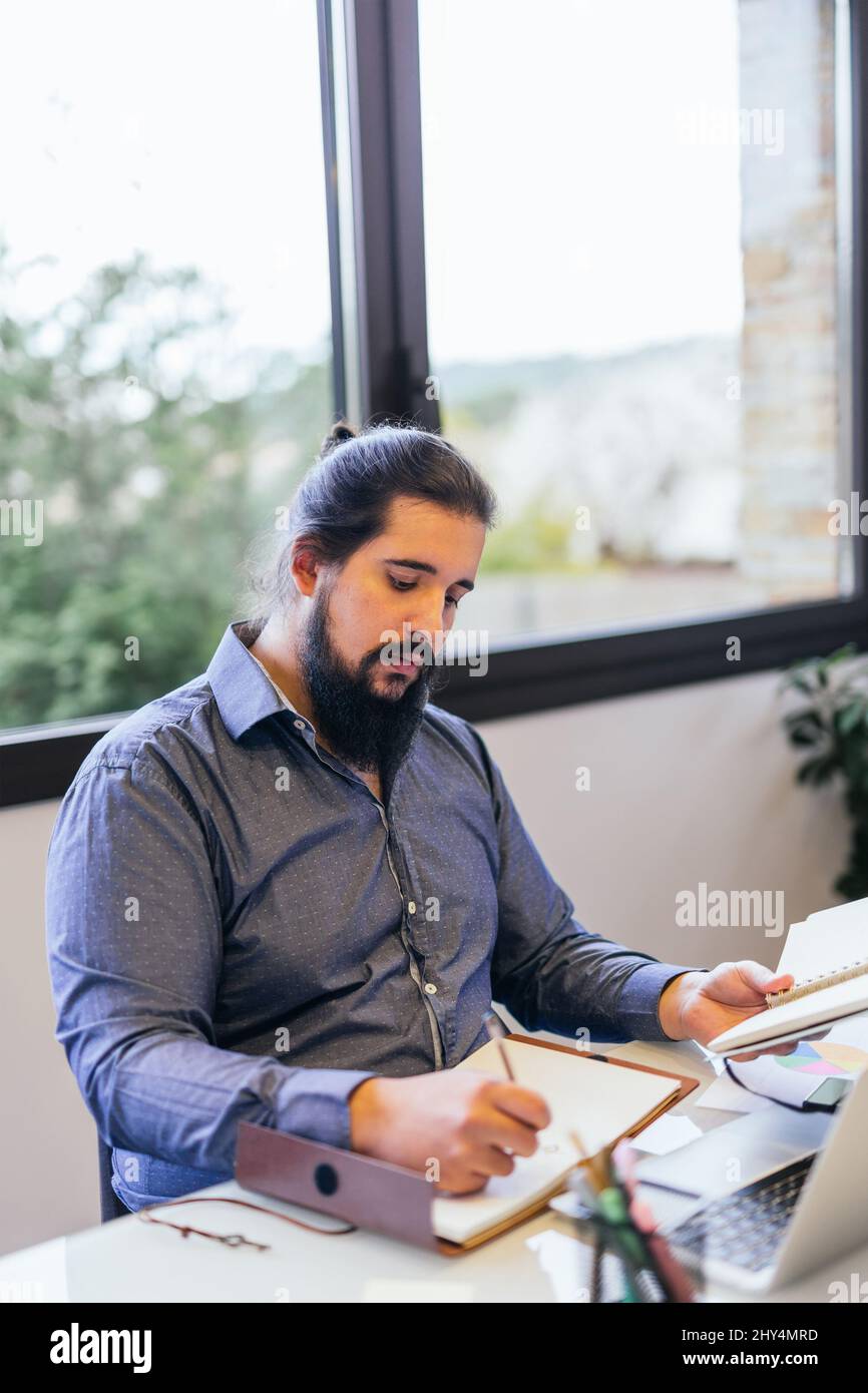 young man working at home as a freelancer preparing an important project Stock Photo