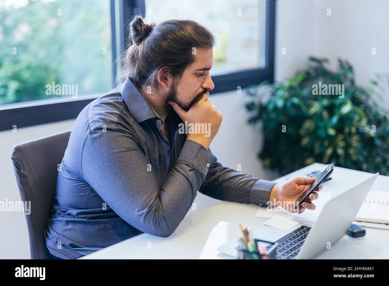 Young entrepreneur concentrating on the mobile phone Stock Photo