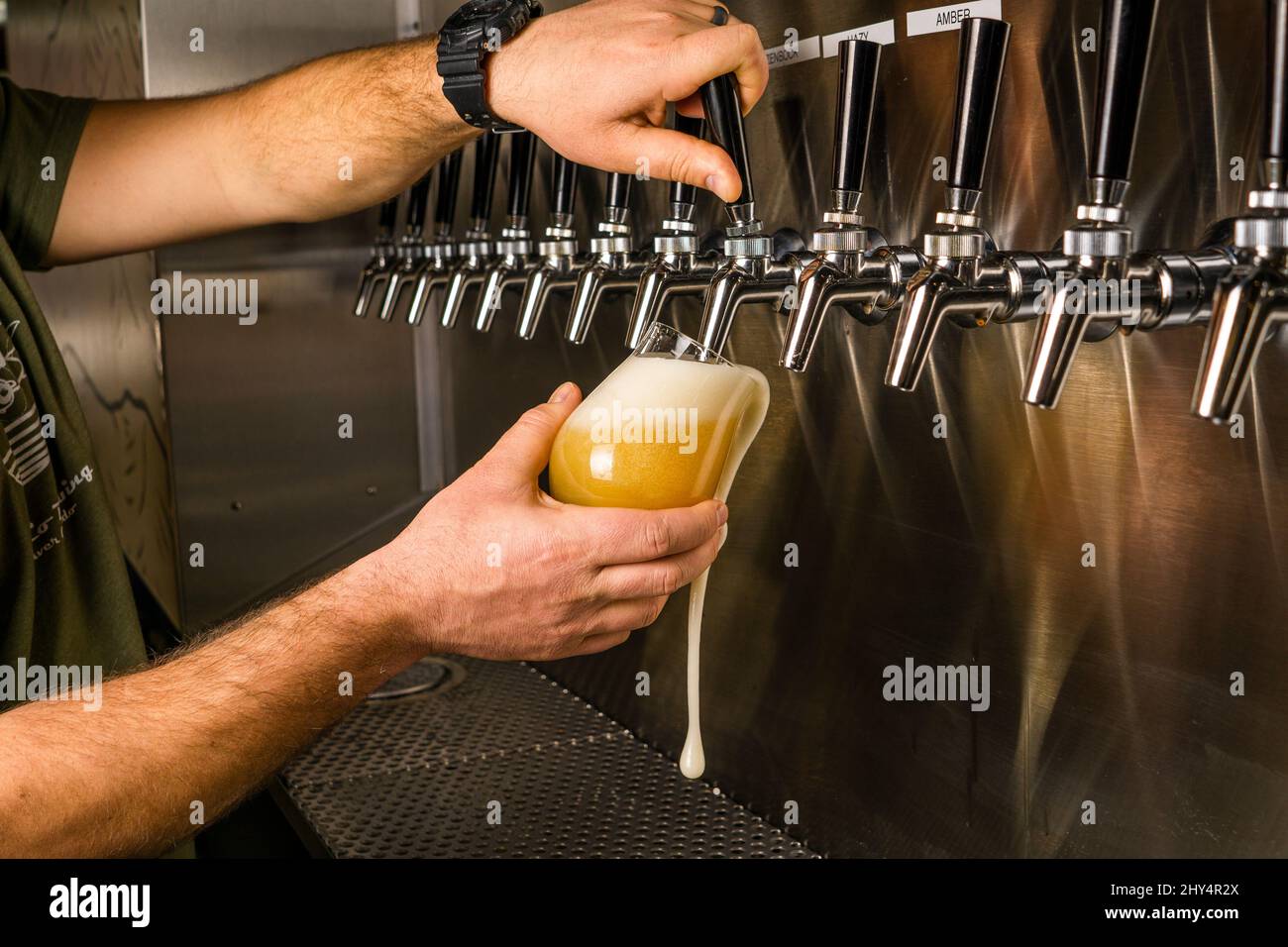 Closeup of a Barman hand at beer tap pouring an Ice Cold IPA Craft Beer