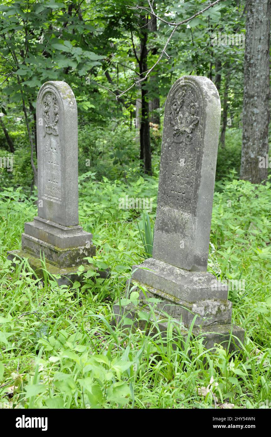 Very old headstones in an overgrown cemetery in Missouri Stock Photo
