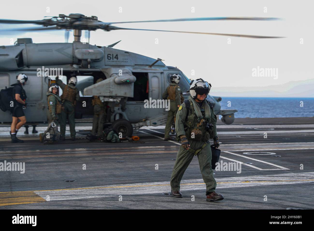 PHILIPPINE SEA (March 13, 2022) Cmdr. Brian Truong, commanding officer of the “Chargers” of Helicopter Sea Combat Squadron (HSC) 14, swaps out of an MH-60S Sea Hawk helicopter on the flight deck of the Nimitz-class aircraft carrier USS Abraham Lincoln (CVN 72). Abraham Lincoln Strike Group is on a scheduled deployment in the U.S. 7th Fleet area of operations to enhance interoperability through alliances and partnerships while serving as a ready-response force in support of a free and open Indo-Pacific region. (U.S. Navy photo by Mass Communication Specialist 3rd Class Javier Reyes) Stock Photo