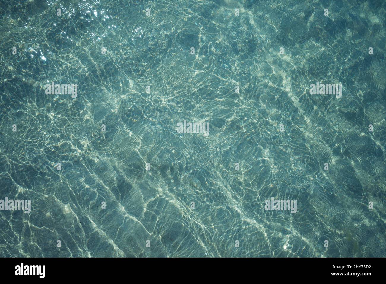 Background shot of aqua sea water surface with sun reflections Stock Photo