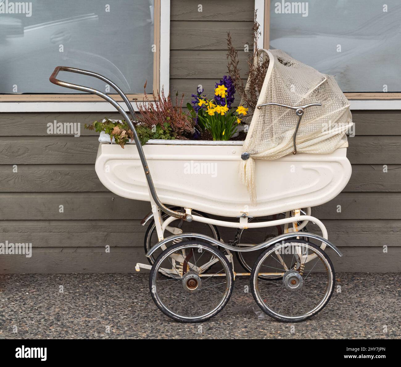 Vintage Pram Baby. Baby stroller decorated with flowers. Vintage baby stroller in beautiful interior with original decoration. Street phot, nobody, se Stock Photo