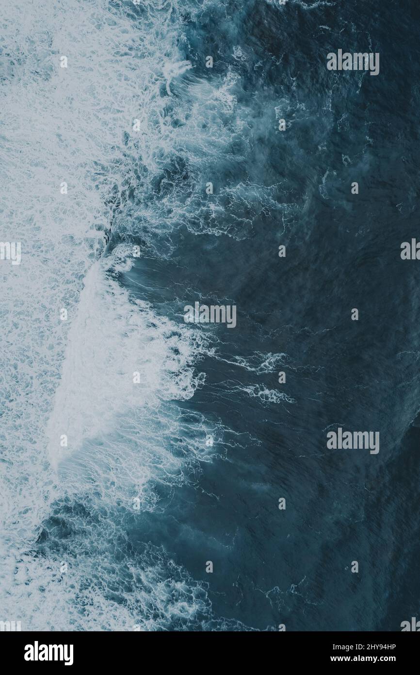 Vertical top view of white wave foam in blue water Stock Photo - Alamy
