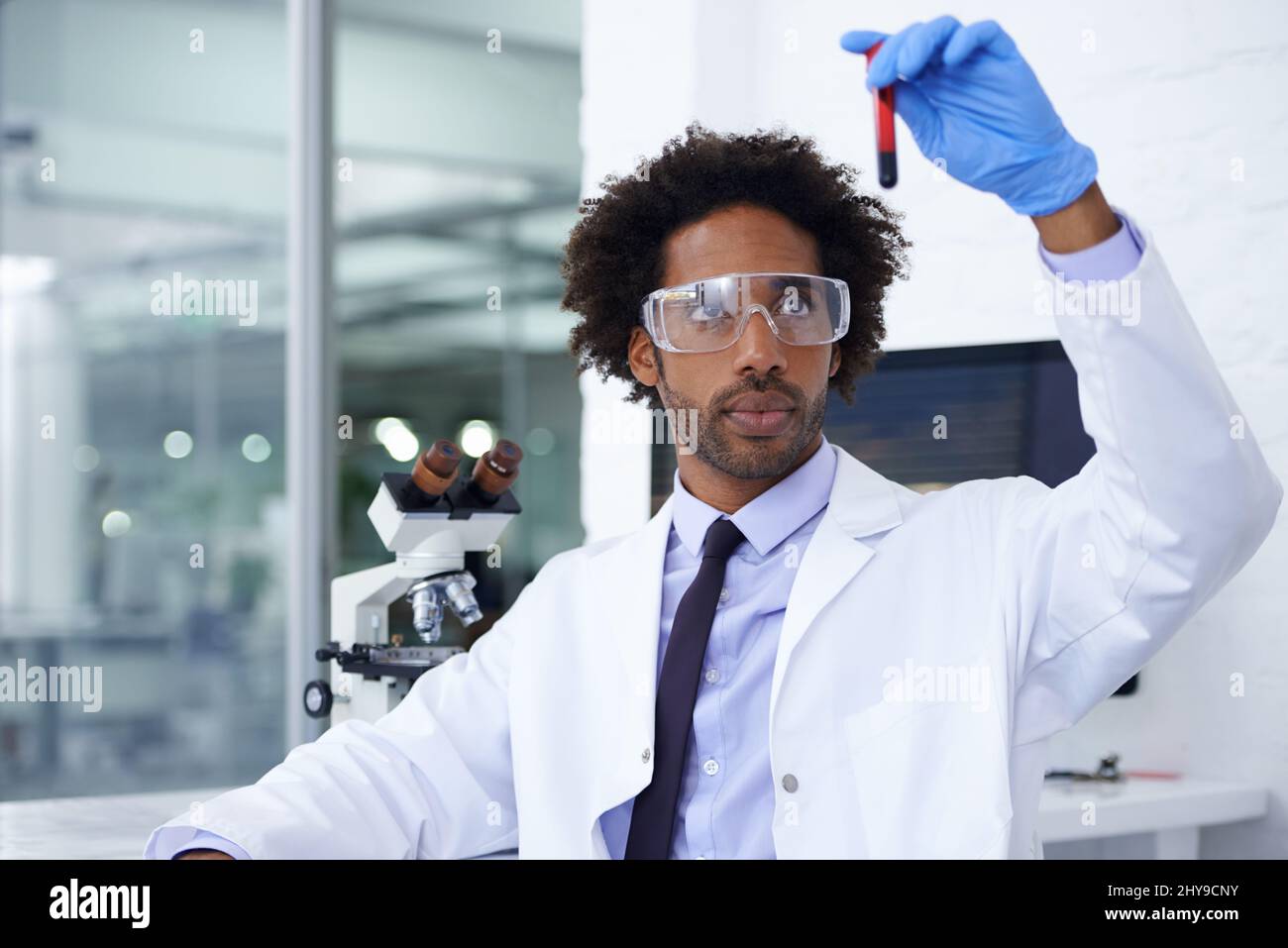 Let the analyzing begin. Shot of a male medical scientist holding a test tube filled with blood. Stock Photo