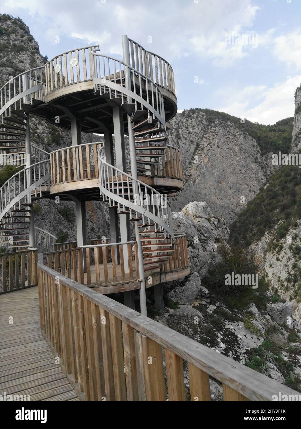 Vertical shot of a wooden bridge with a round-shaped staircase on a ...