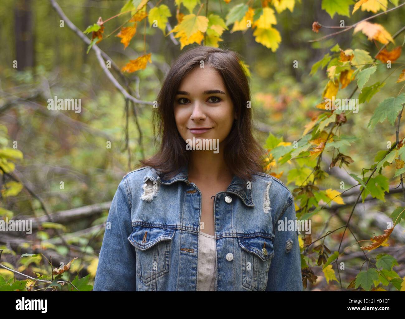 Portrait of russian young girl looking in camera against forest Stock Photo