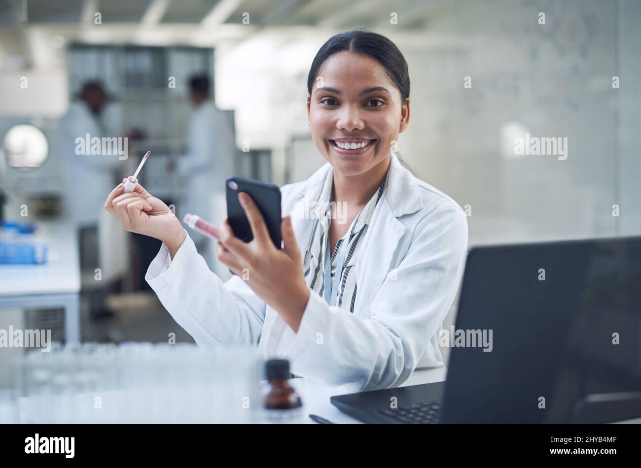 Our cruelty free cosmetics keep you looking good minus the guilt. Shot of a young scientist applying makeup using a smartphone while conducting Stock Photo