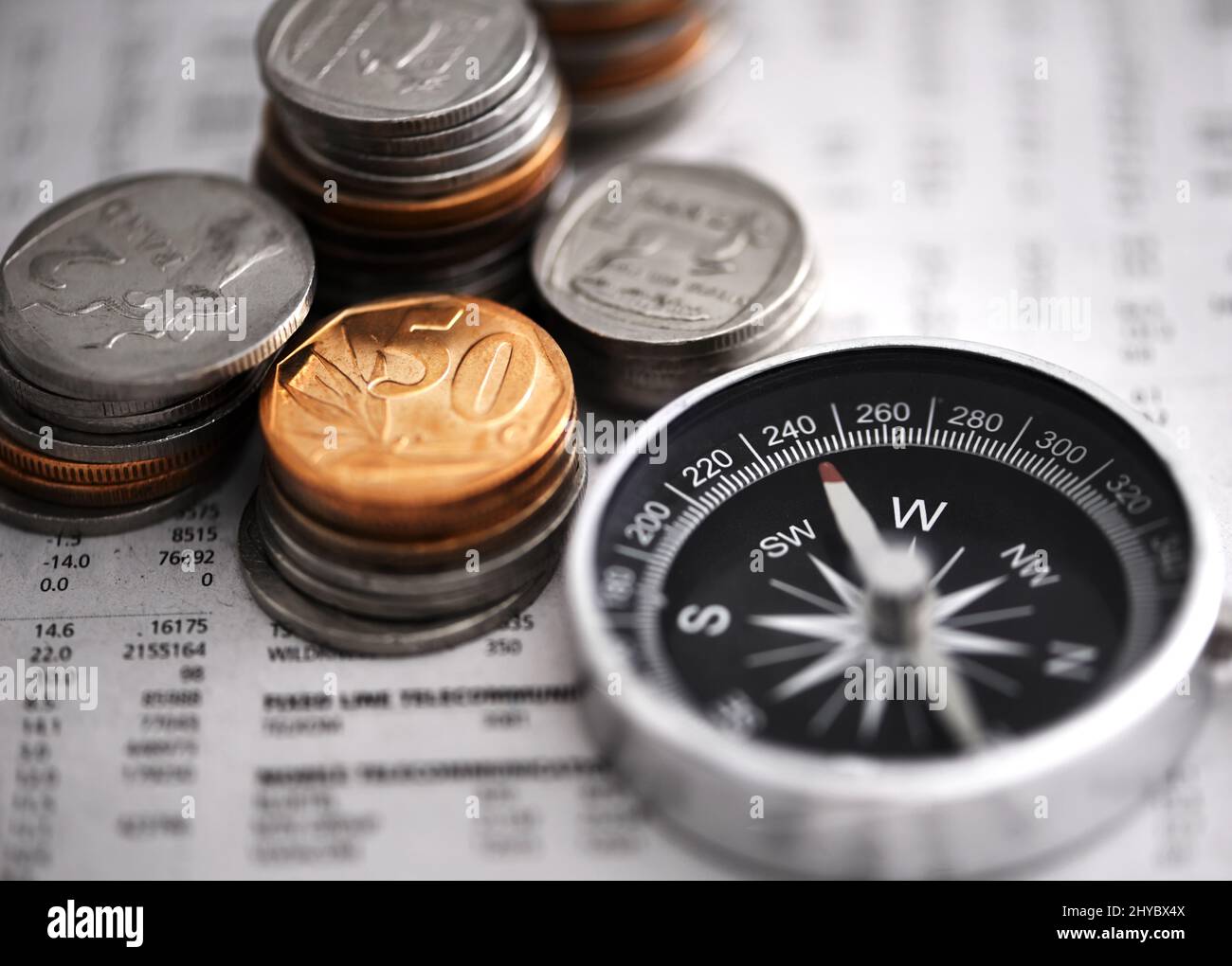 Leading the way to financial success. Studio shot of coins and a compass on some documents. Stock Photo