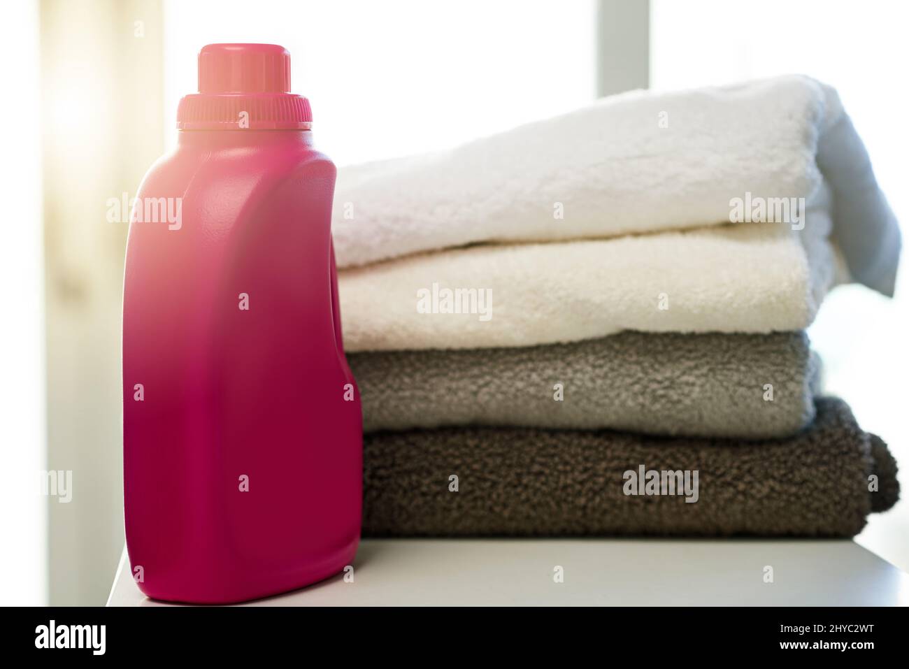 Who doesnt love clean towels. Shot of a bottle of detergent alongside a pile of folded towels at