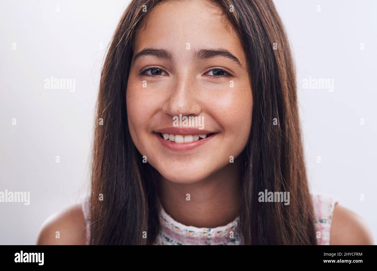 Just smile. Cropped portrait of an attractive teenage girl standing alone against a white background in the studio. Stock Photo