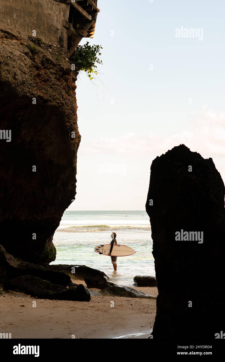 A man walking on the beach with a surfboard Stock Photo - Alamy