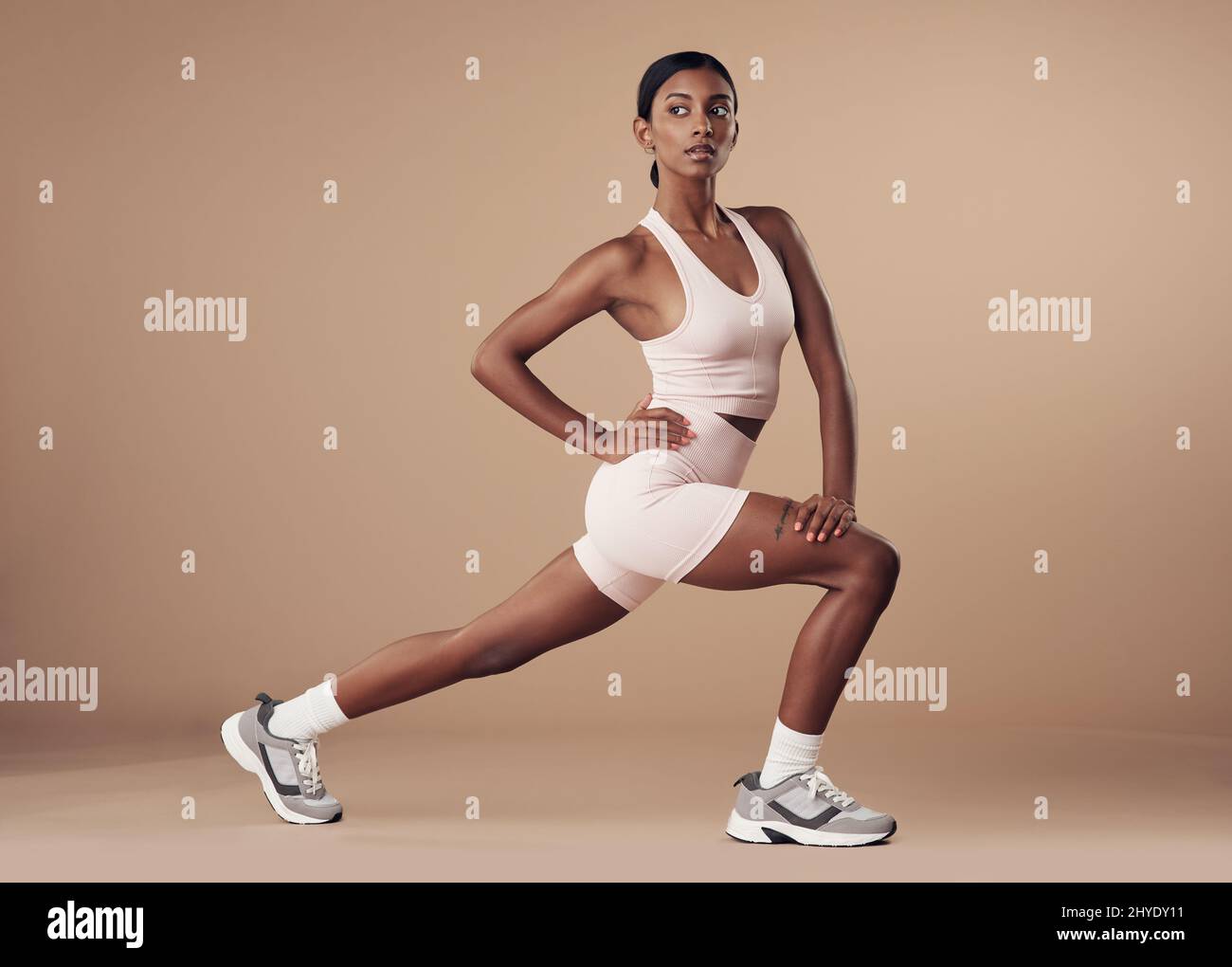 Working those quads and glutes. Full length shot of an attractive young woman working out in the studio and holding a lunge position Stock Photo Alamy