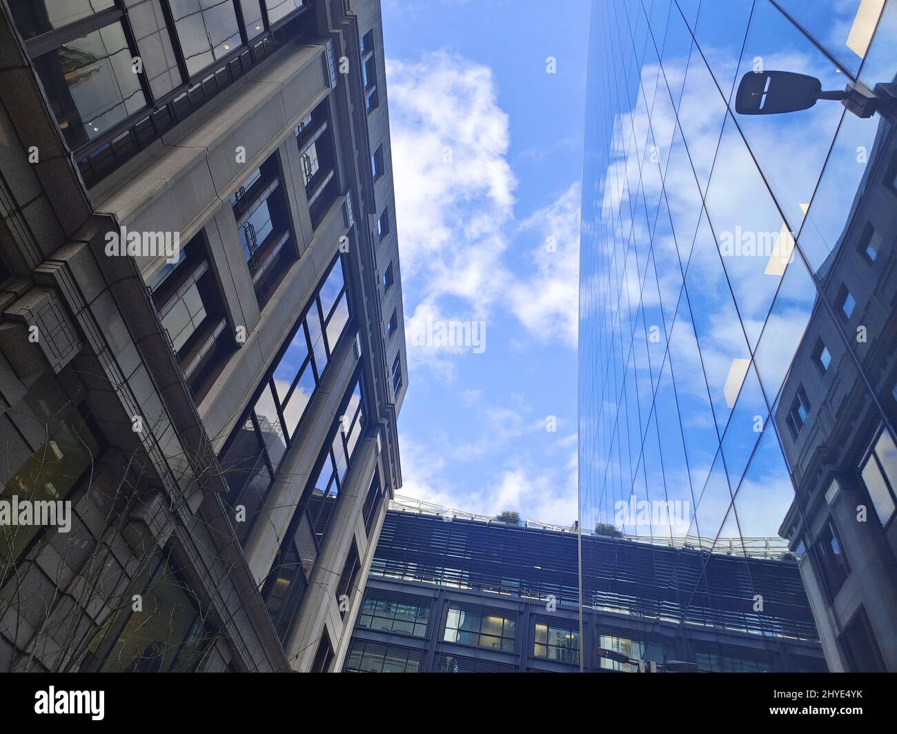 Low angle of a glass-walled buildings under a bright cloudy sky Stock ...
