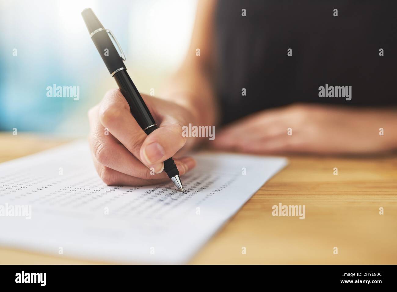 Assessment time. Shot of a woman filling in an answer sheet for a test. Stock Photo