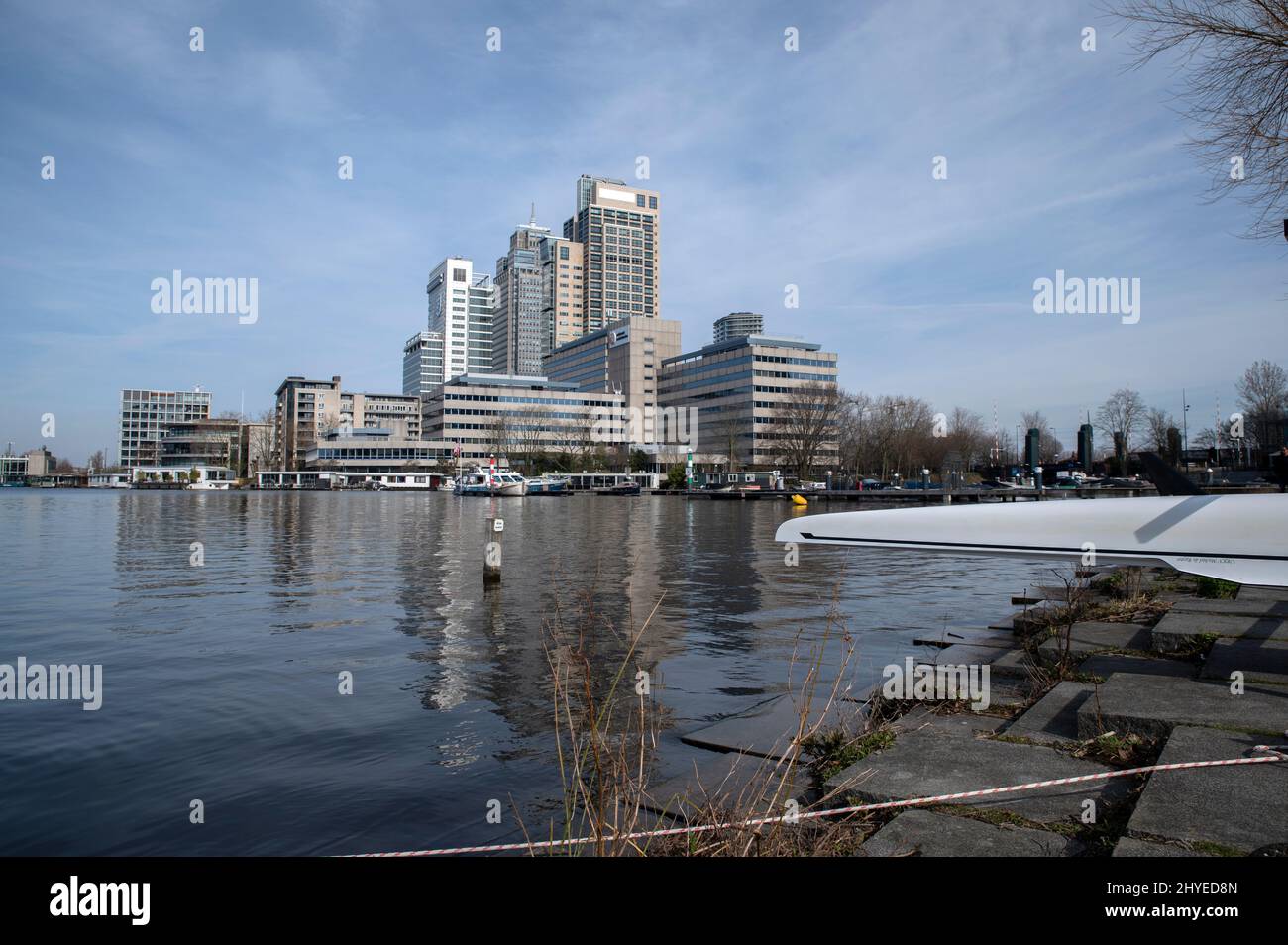 Rowing Boat On The Side Of The Business Skyline From Park Somerlust At The Amstelriver Amsterdam The Netherlands 13-3-2022 Stock Photo