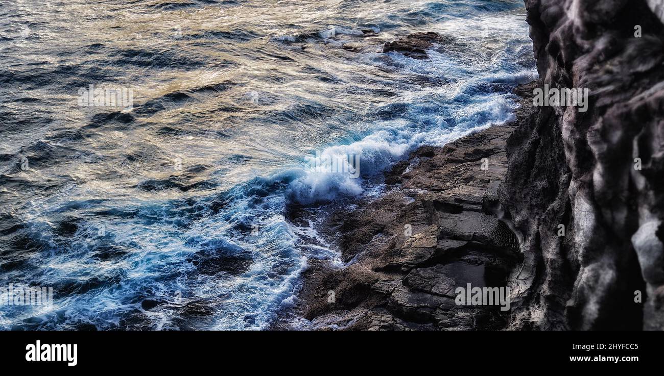 Amazing top shot of wave foam and ocean rocks Stock Photo - Alamy