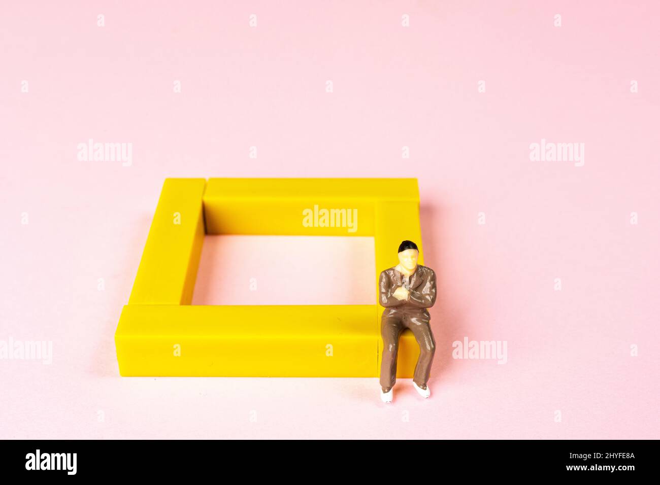 a man sitting at the edge of a colored square Stock Photo