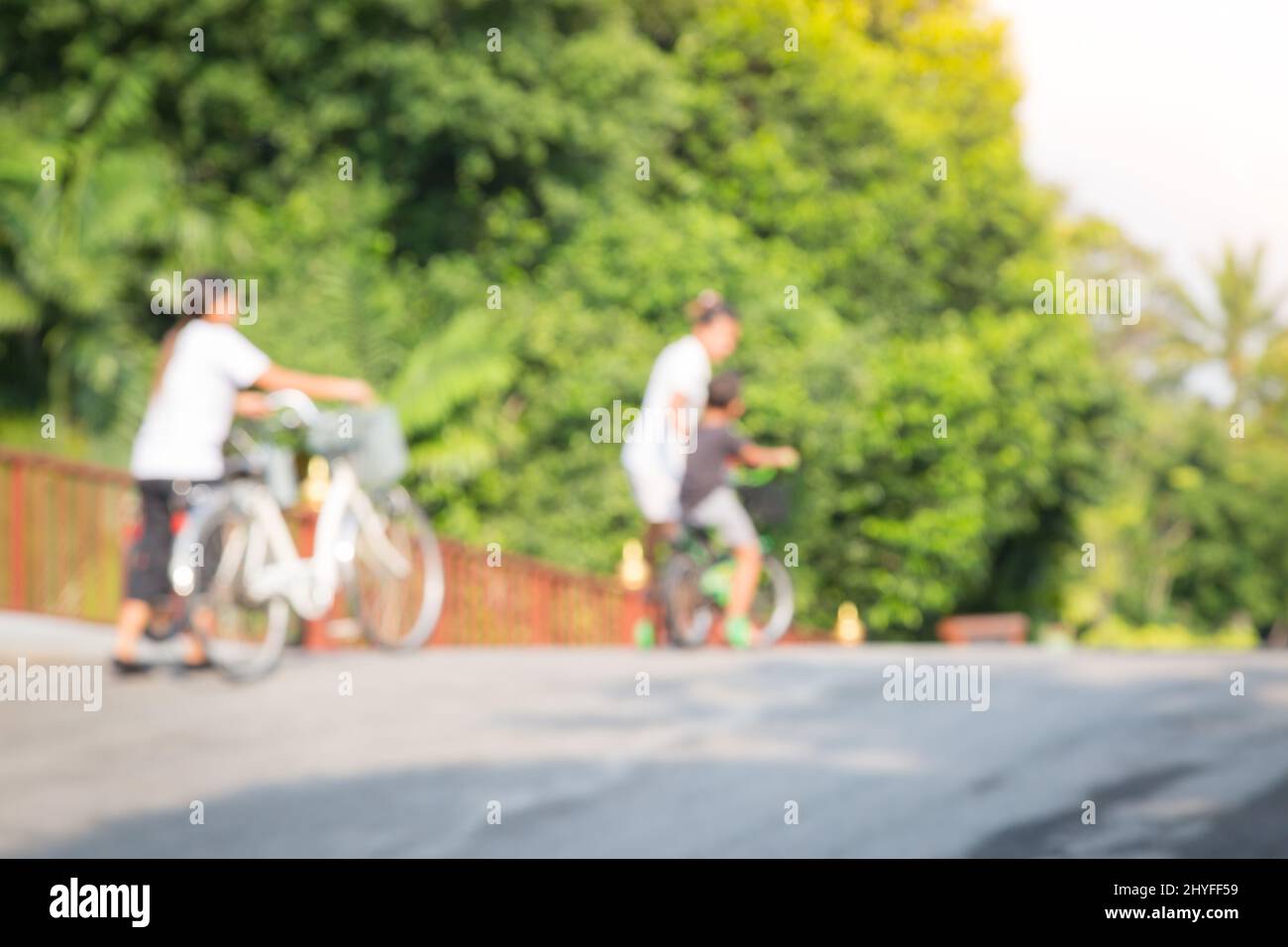 Children are learning to ride a bike at the public park in Thailand Stock Photo