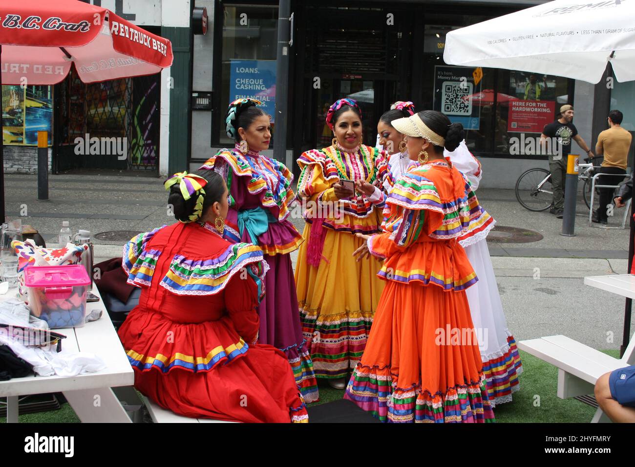 Mexican female dancers in colorful dresses in the street of a downtown