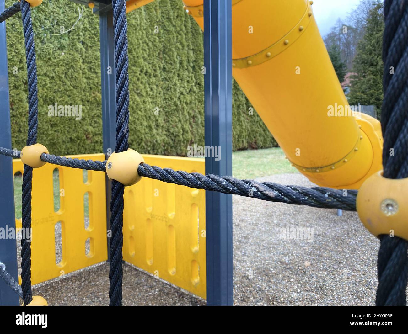 Children's playground with a yellow slide and blue ropes Stock Photo