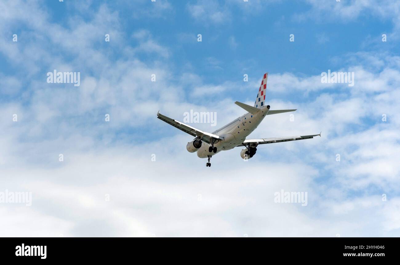 Passenger jet airplane in mid-flight against blue sky with clouds ...