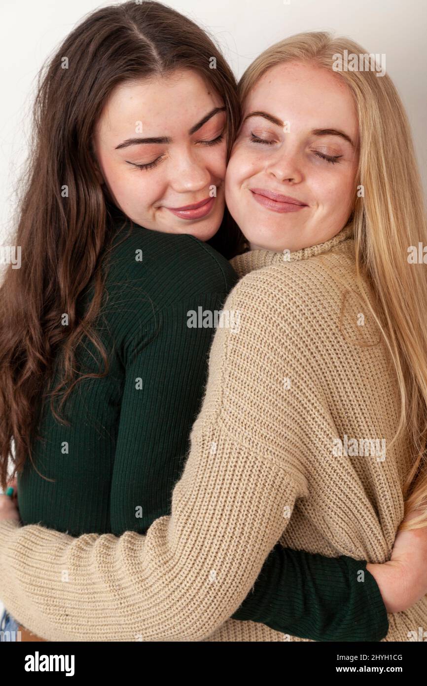 Two young female friends hugging each other Stock Photo - Alamy