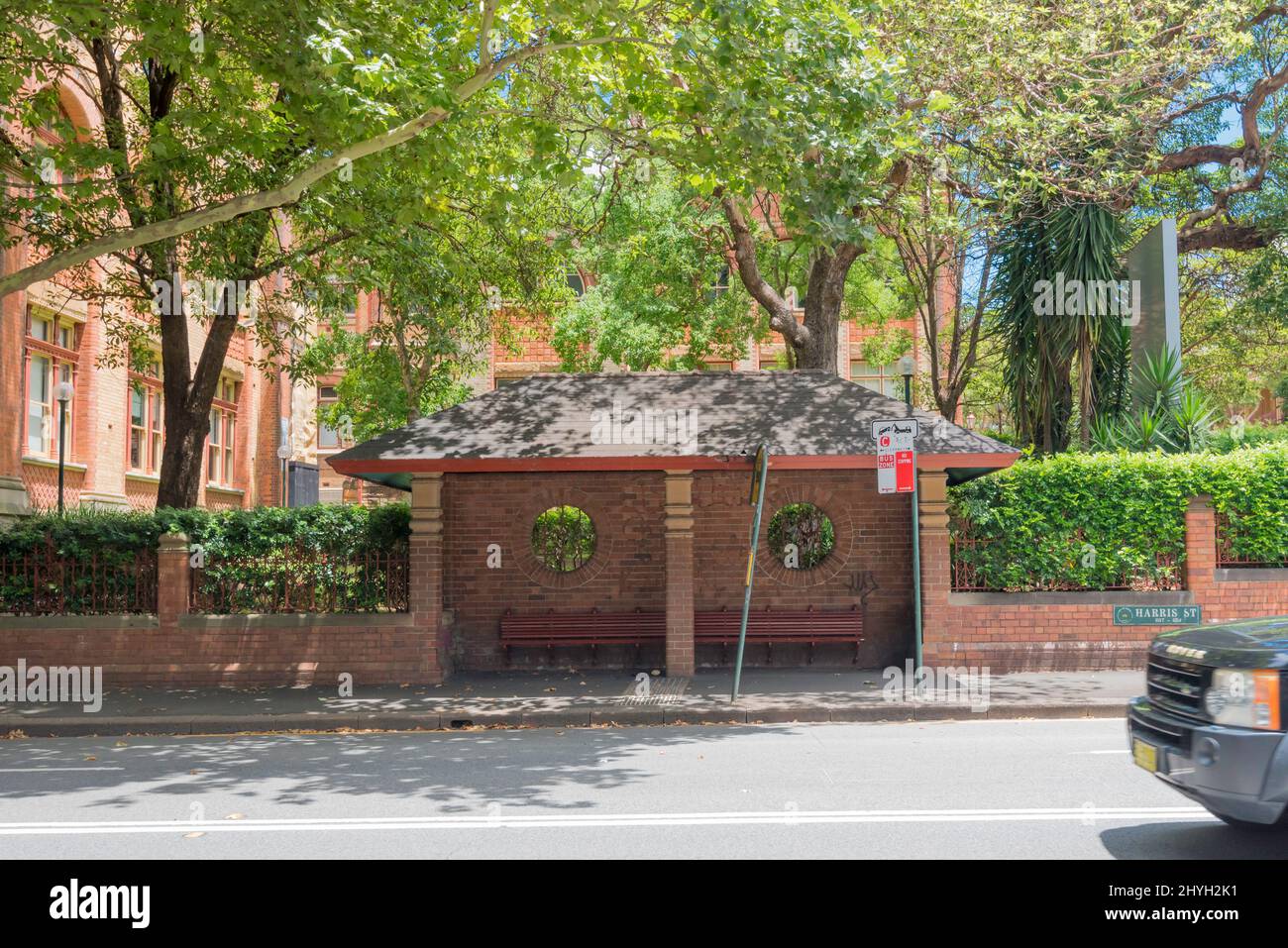 A slate roofed and polychrome brick with Pyrmont sandstone bus stop in Harris Street, Ultimo, Sydney is part of the 1892 Sydney Technical College TAFE Stock Photo