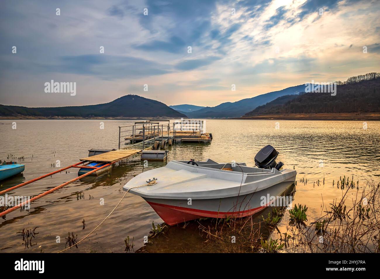 Moored wooden boat after sunset at the lakeshore Stock Photo - Alamy