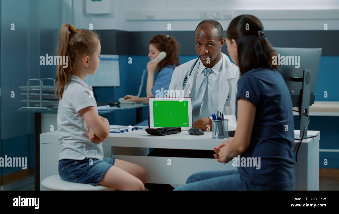 Medic holding digital tablet with horizontal green screen in medical