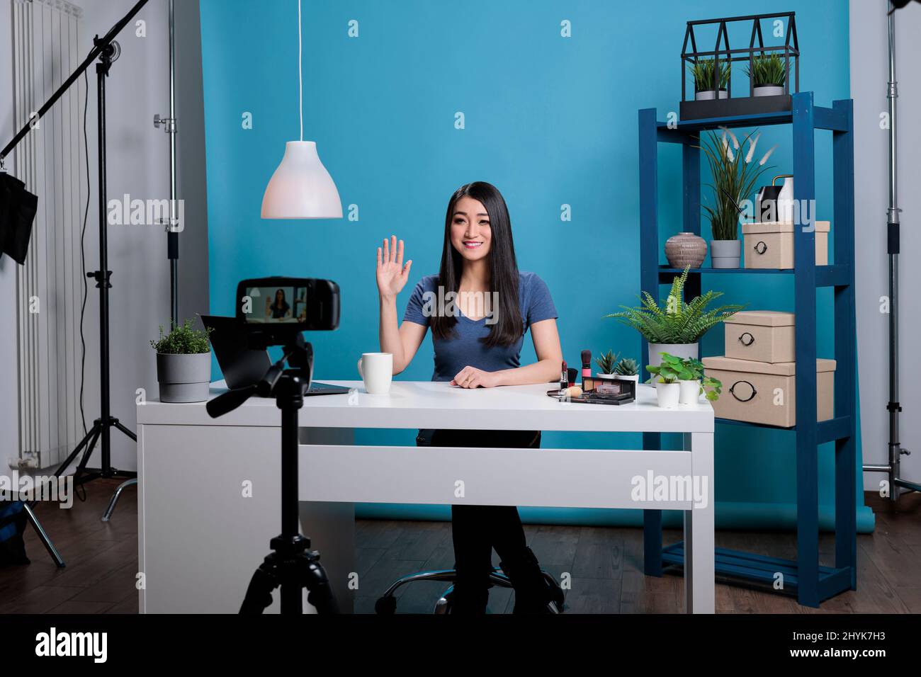 Social media influencer greeting remote fans while recording make up