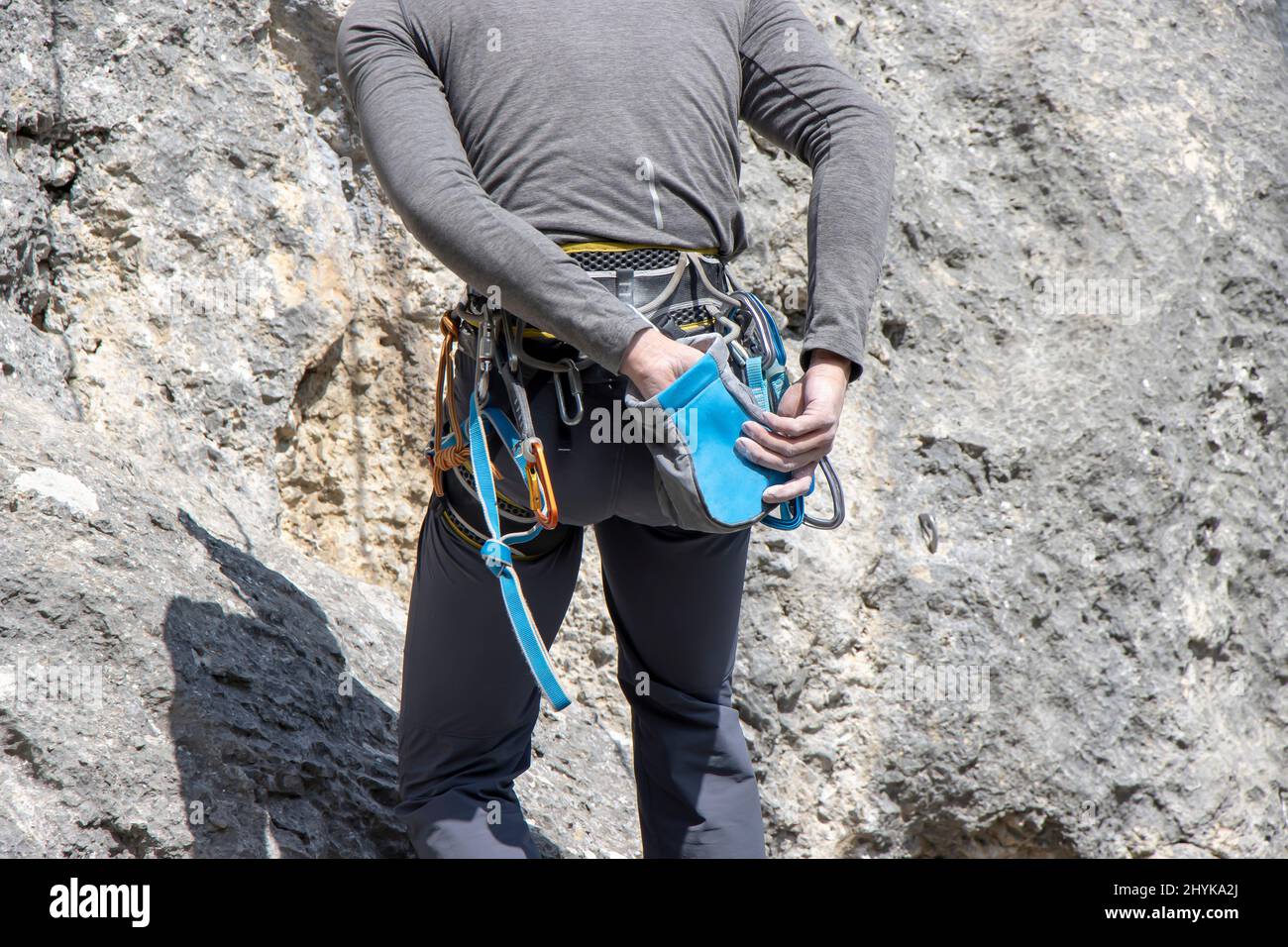 A young climber takes magnesium in his hands before climbing a rock Stock Photo