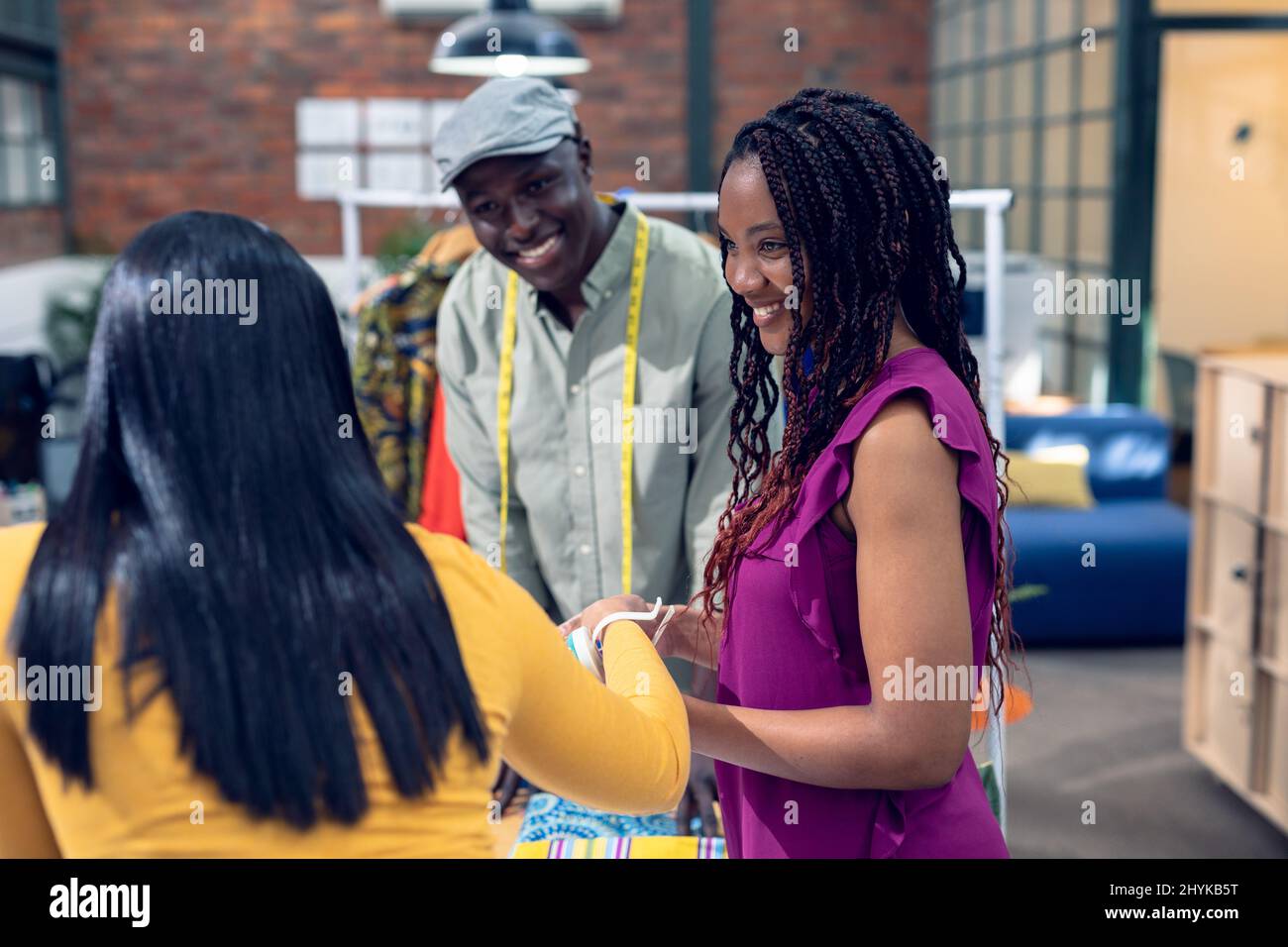 Smiling multiracial young male and female fashion designers talking ...