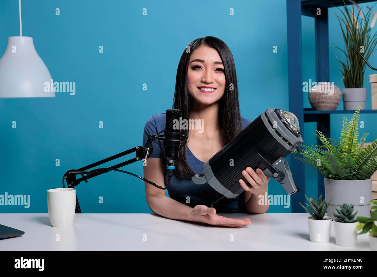 Portrait of asian creator vlogger reviewing studio light on camera for
