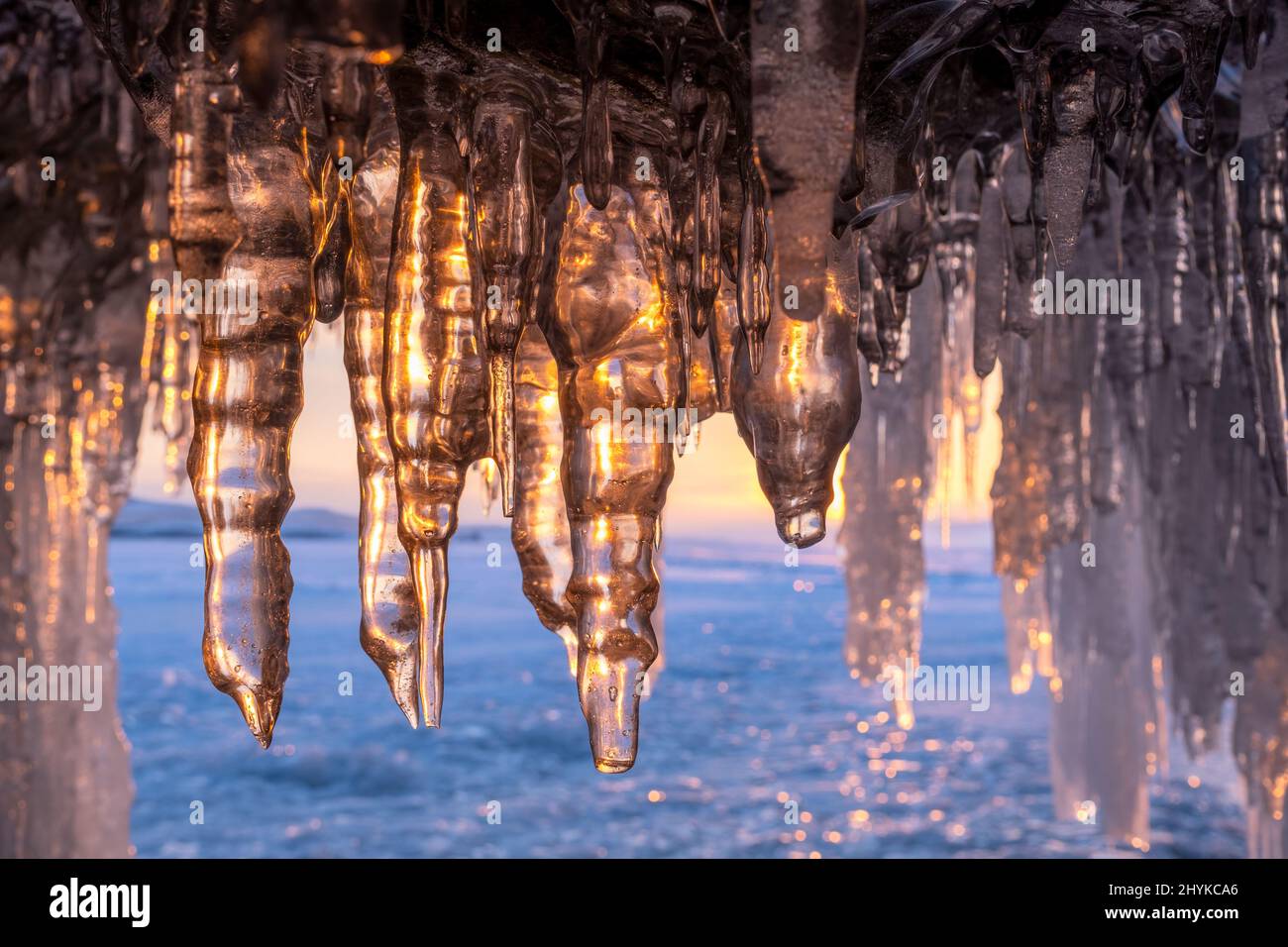 Icicles in cave on Baikal lake at sunset Stock Photo