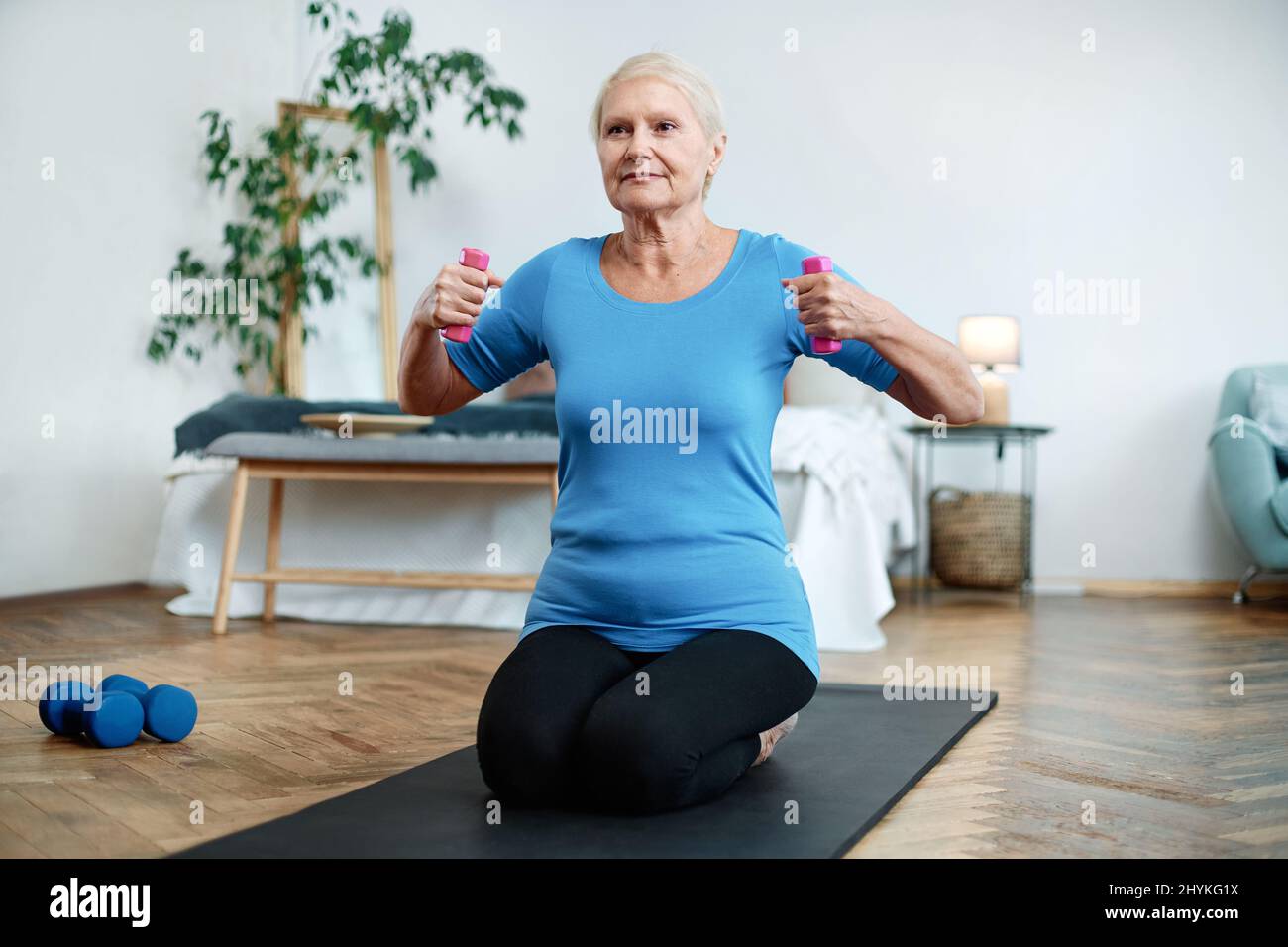 elderly woman sitting in a yoga pose in front of an open laptop Stock ...