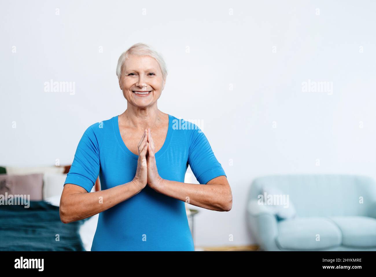 elderly woman sitting in a yoga pose in front of an open laptop Stock ...