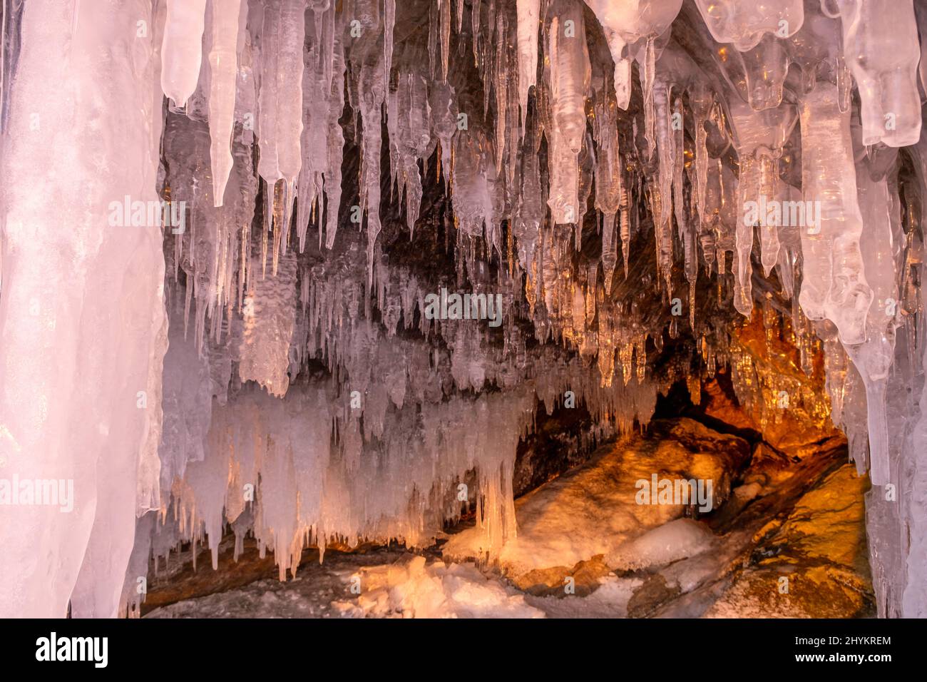 Icicles in cave on Baikal lake at sunset Stock Photo