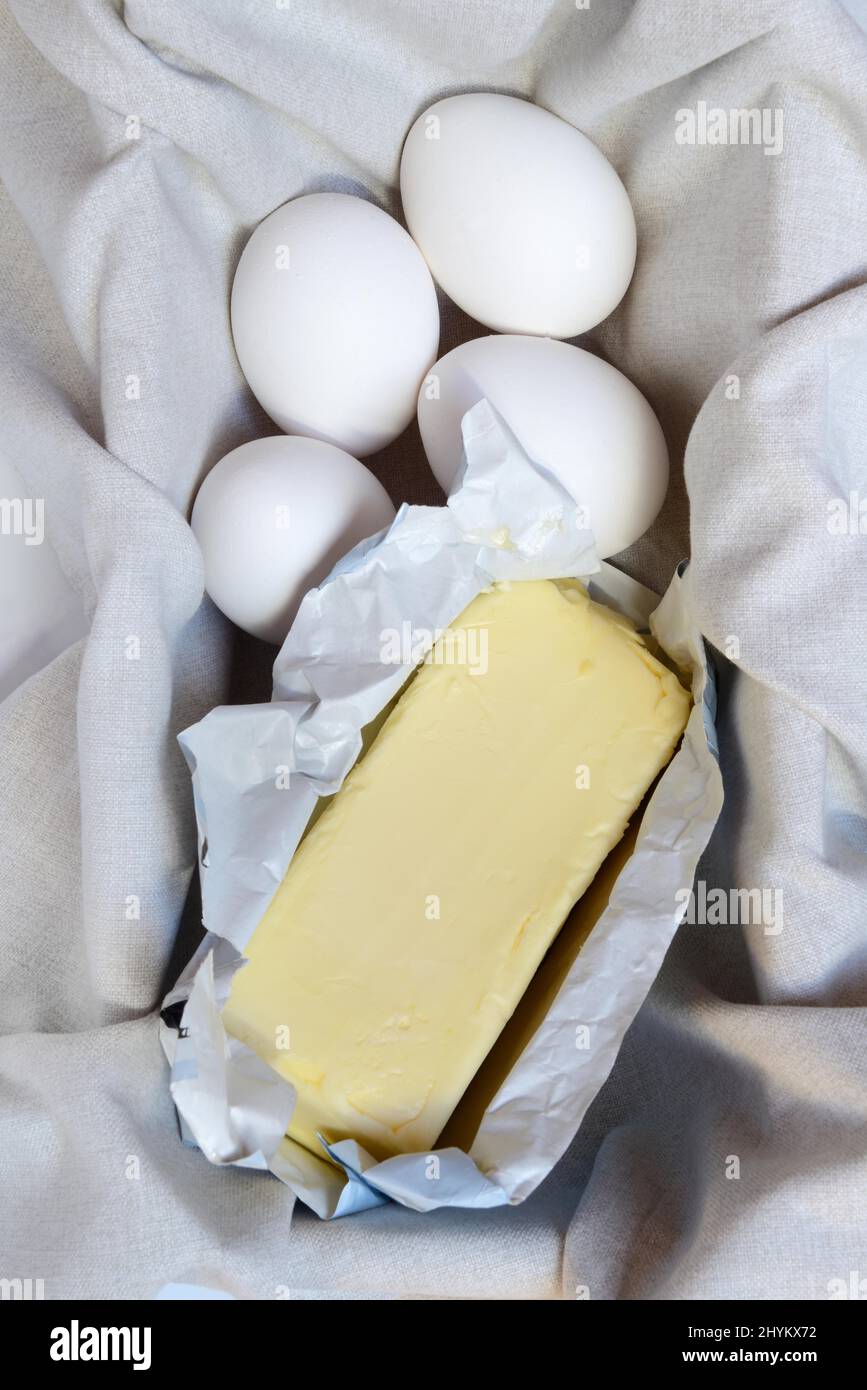 Butter in opened packaging and eggs Stock Photo