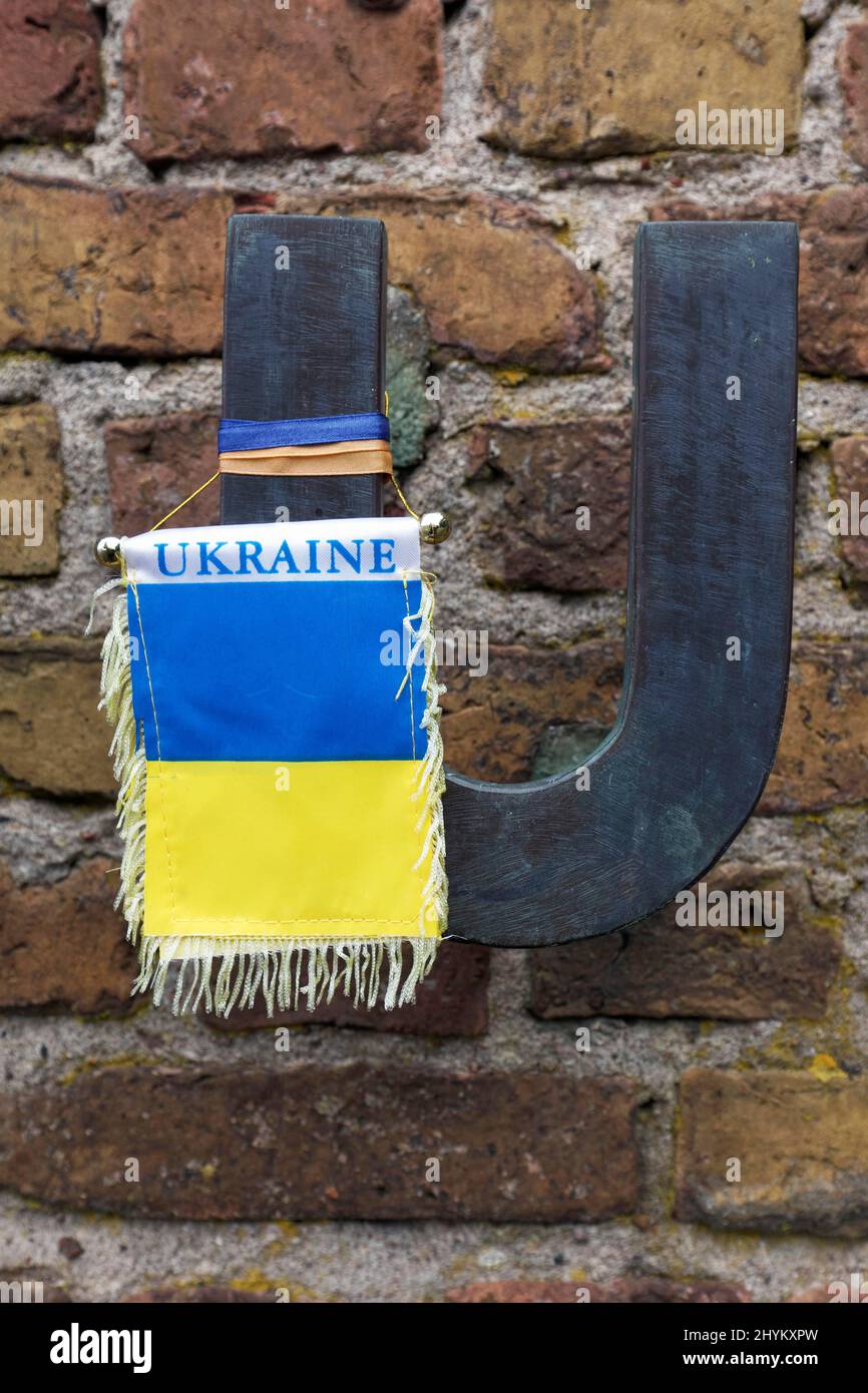 Flag in the national colours of Ukraine hanging from the letter U of Russia, in memory of the Ukrainian concentration camp victims, Wall of Nations Stock Photo