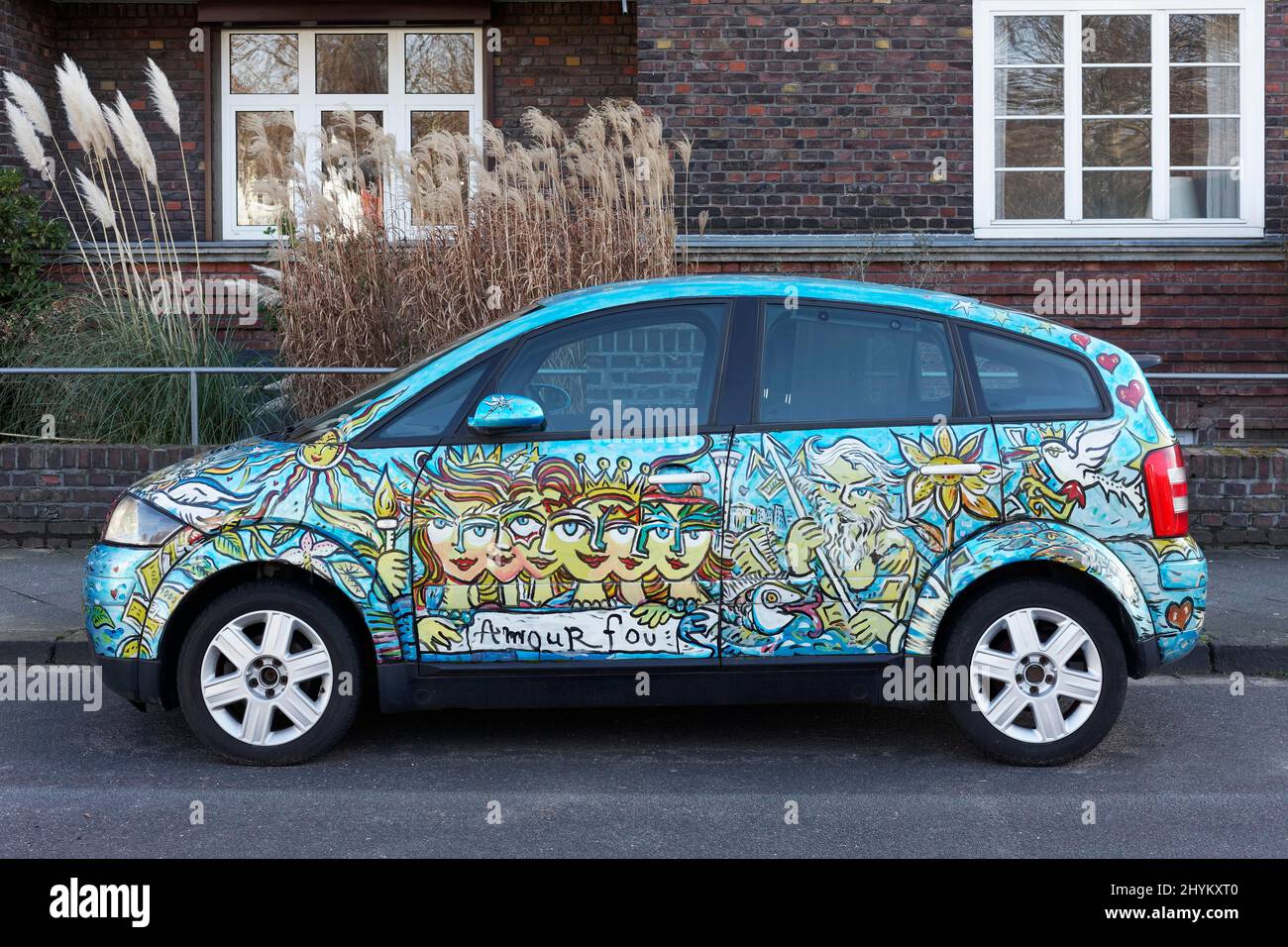 Artistically painted Audi A2 parked in front of residential building, motto Amour fou, crazy love, Duesseldorf, North Rhine-Westphalia, Germany Stock Photo