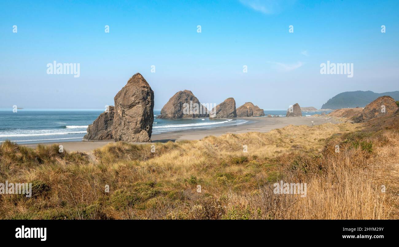 View over sandy beach with dunes and large rocks, coastal landscape