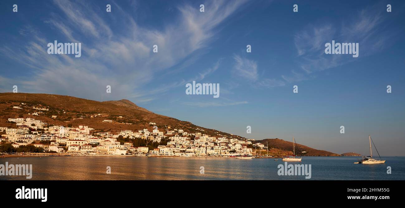 Panorama, Picturesque harbour village of Batsi, Soft evening light, Sailboat, Catamaran, Harbour, Houses on the slope, Hills in the background, Sky Stock Photo
