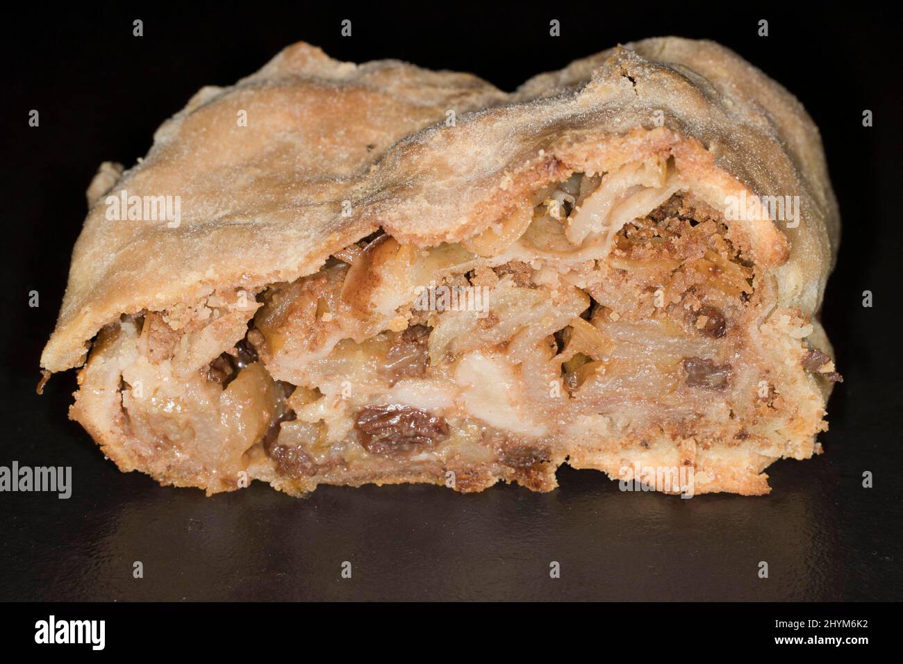 Apple strudel with sultanas, studio photography with black background Stock Photo