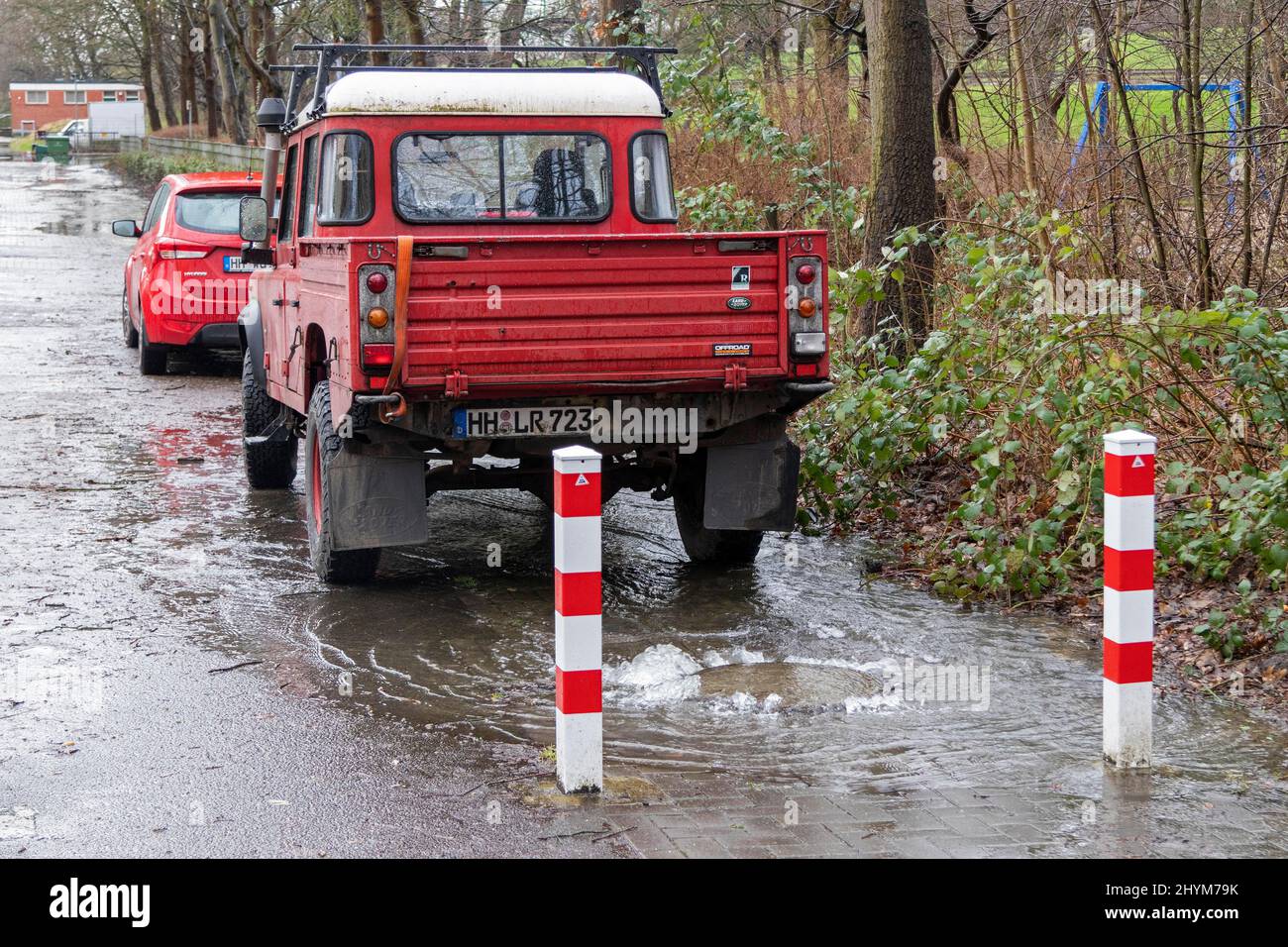 Water pouring out of a manhole cover, Wilhelmsburg, Hamburg, Germany