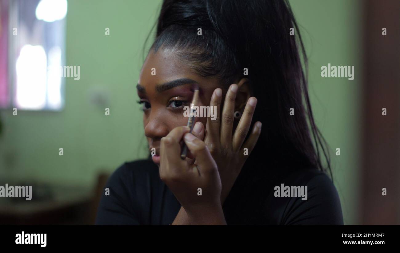 A black teen girl applying make-up in front of mirror a young woman  preparing to go out Stock Photo - Alamy