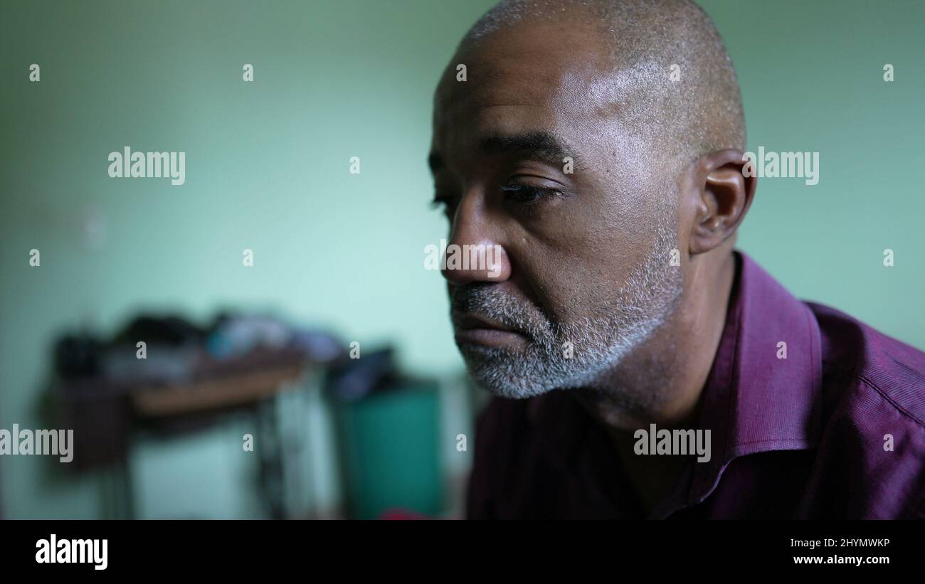 A preoccupied person an African senior man having despair and anxiety ...