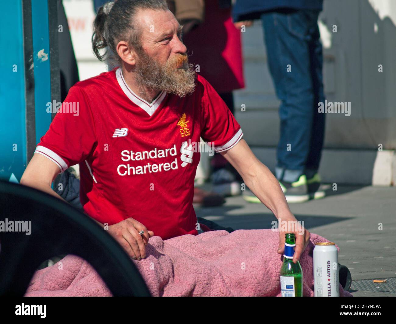 A Liverpool football fan down on his luck in Brighton Stock Photo